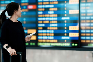 Woman Checking Flight Information at Airport Departure Board