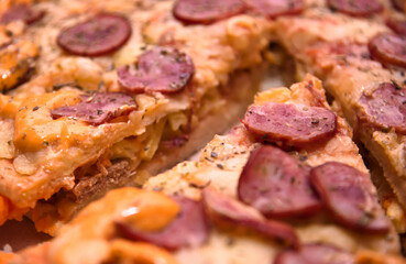 Double pizza stuffed with meat and vegetables inside and calabreza sausage topping on top. Close view