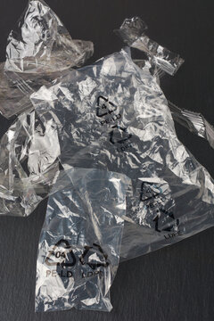discarded recyclable clear plastic bags on textured black surface, thin and lightweight plastic or low density polyethylene of packaging or produce bags 