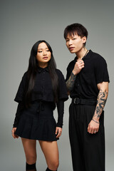 Stylish couple showcasing modern fashion in a minimalist studio setting