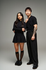 Stylish couple exudes romance in chic black attire against a neutral backdrop