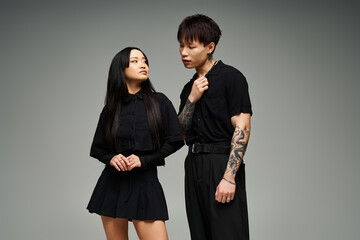 Stylish couple showcases contemporary fashion with elegance and charm in a modern setting