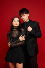 Stylish couple embracing romance in a vibrant setting with bold colors and chic outfits