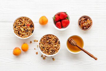 Flat lay of oatmeal granola and ingredients served on white table. Healthy breakfast