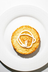 Golden toasted English muffin with creamy swirl on a white plate, breakfast simplicity, brunch delight, Easter treat concept