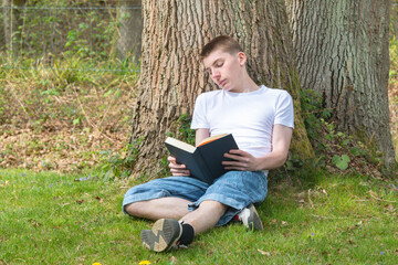 Fototapeta premium Teenage Boy Reading Outdoors