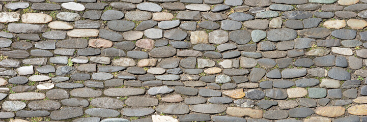 Panoramic image. Sidewalk made of old cobblestones