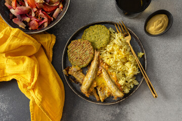A savory, balanced breakfast with turmeric rice, baked ocean fish, broccoli pancakes, and roasted vegetable salad, providing essential proteins and healthy fats for an energizing start