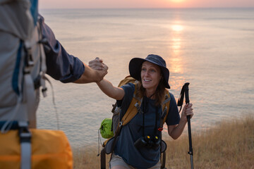 Hikers or explorers on journey carrying backpack, trekking poles looks into the distance observing and possibly guide trekking and trail exploration holiday ecotourism concept.