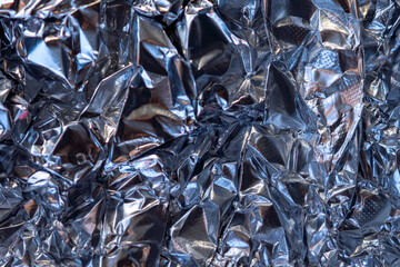 abstract background, futuristic crumpled metallic aluminum foil silvr, light blue, dark grey and mauve, dent space in center
