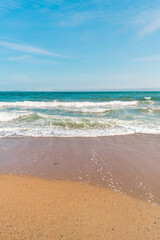 Background sea beach with waves and foam. Sandy beach and sea turquoise waves. Feeling of carelessness, enjoyment of freedom and happiness.