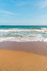 Background sea beach with waves and foam. Sandy beach and sea turquoise waves. Feeling of carelessness, enjoyment of freedom and happiness.