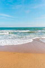 Background sea beach with waves and foam. Sandy beach and sea turquoise waves. Feeling of carelessness, enjoyment of freedom and happiness.