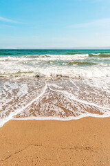 Background sea beach with waves and foam. Sandy beach and sea turquoise waves. Feeling of carelessness, enjoyment of freedom and happiness.