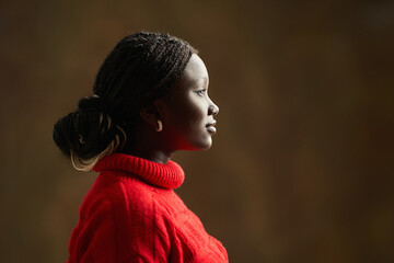 Young black woman wearing red sweater and looking right side