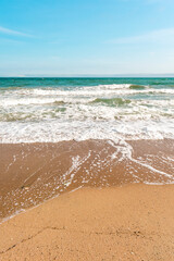 Background sea beach with waves and foam. Sandy beach and sea turquoise waves. Feeling of carelessness, enjoyment of freedom and happiness.