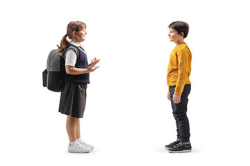 Girl in a school uniform carrying a backpack and talking to a boy