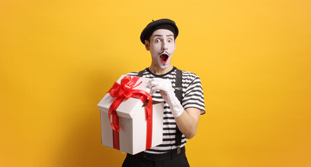 Surprised mime holding a gift box