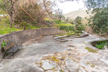 a bench and a fountain in a park .La vall de gallinera, Alicante, Spain