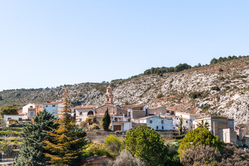 Obraz premium a small village on a hillside with trees and a church.La vall de gallinera, Alicante, Spain