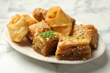 Tasty Turkish baklava on white marble table, closeup