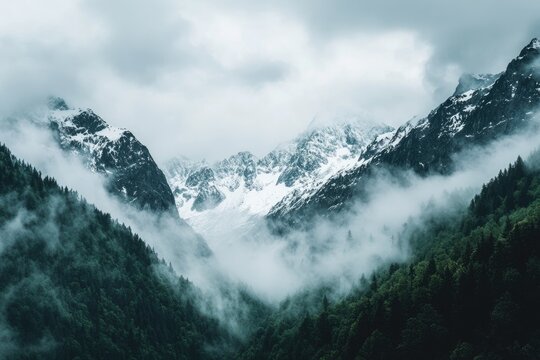 Misty mountain peaks shrouded in clouds, snow-capped summits, lush green valleys