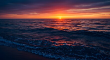 Fototapeta premium A stunning sunset over a calm ocean, with vibrant colors reflecting on the water's surface.