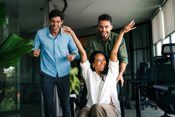 Group of young multiracial diverse office workers is caught in a moment of spontaneous joy.
