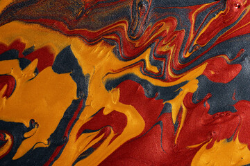 Vibrant metallic paint swirls on abstract background