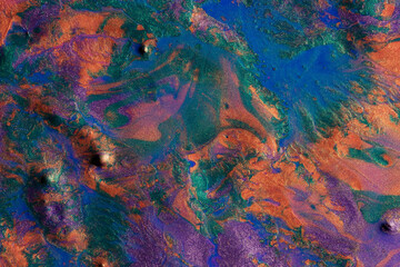 Colorful metallic paints create a vivid abstract background