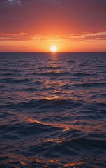 Fototapeta premium A breathtaking sunset casts vibrant hues of orange, pink, and purple across the sky, reflecting on the calm ocean waters, while gentle waves lap at the sandy shore.