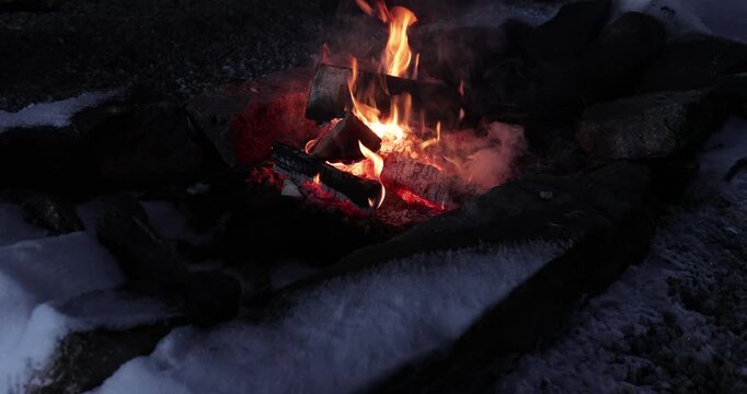 Flames of a fireplace in the snow, wood fire in refuge hut