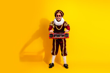 Man Wearing Nobleman Costume with Boombox in Retro Style Posing on Yellow Background