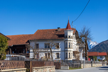 Obraz premium Historic residential building with red tiled roof and small turret in alpine village, Karres, Austria..