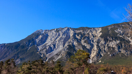 Steep rock face and forested mountain slopes in spring, Ötztal, Austria..