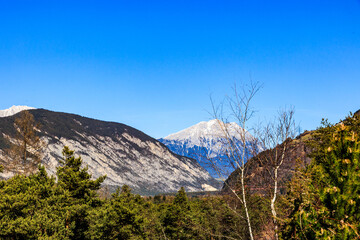 Mountain ranges with forested slopes and snow-covered peaks in spring, Ötztal, Austria..