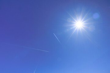Sunny blue sky with contrails from passing aircraft..