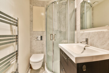 A sleek, contemporary bathroom featuring a glass shower enclosure, stylish sink, and elegant tile work for a refreshing ambiance.