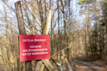 Czerwona tabliczka ostrzegająca o ostoi zwierzyny