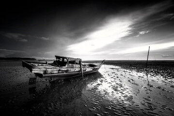 Black and white photo of a bridge over the sea at sunset.