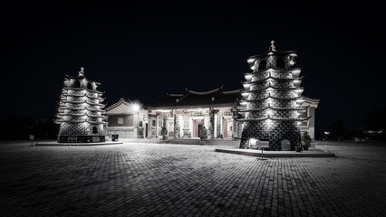 Black and white photo of a bridge over the sea at sunset.