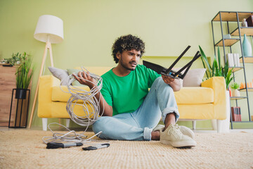 Full size photo of nice young man hold wifi router cable weekend green interior apartment indoors