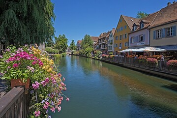 Fototapeta premium Canal view with colorful flowers and buildings under blue skies on sunny day