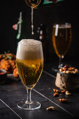 Glass of light beer on dark background. Selective focus