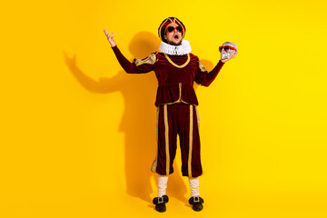 Young man in medieval-style costume holding a skull with sunglasses in a performance setting...