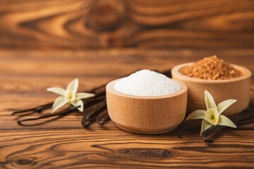 Aromatic vanilla sugar. Vanilla pods. Vanilla sticks, brown and white sugar in a bowl on a textured background. Vanilla flowers, spices and herbs for desserts and baking. Space for text. Copy space