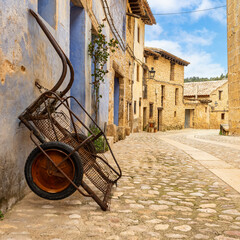 Picturesque street with colorful houses and an old metal cart to transport belongings, Valderrobres, Teruel.