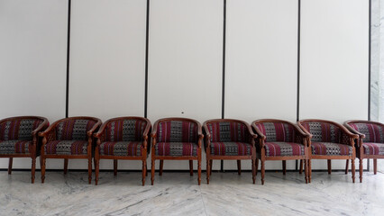 Row of Vintage Patterned Armchairs Against White Wall in Minimalist Setting