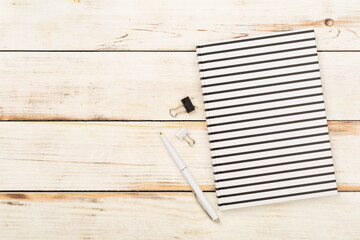 Notebook with stationary on wooden background, top view