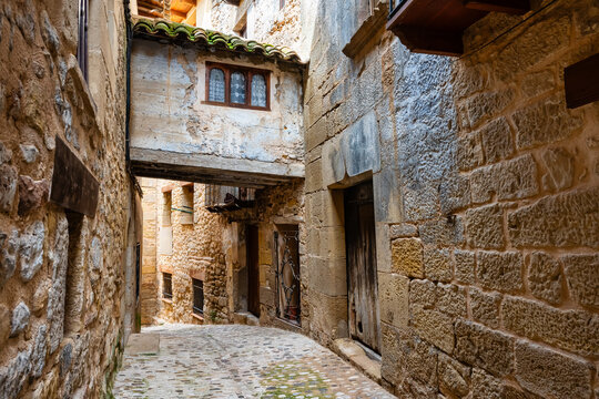 Narrow alley with stone houses and elevated passageways between the medieval houses, Valderrobres, Teruel.